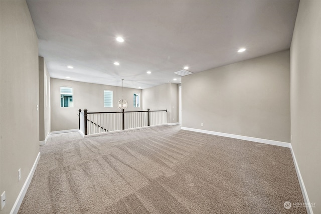 empty room with a chandelier and carpet flooring