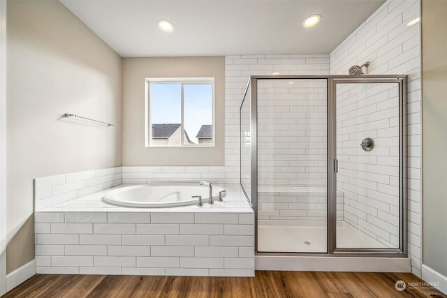 bathroom with independent shower and bath and hardwood / wood-style flooring