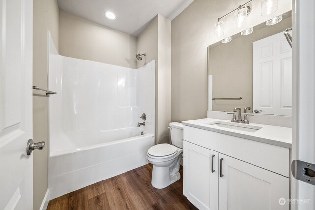 full bathroom featuring vanity, toilet, hardwood / wood-style flooring, and bathing tub / shower combination