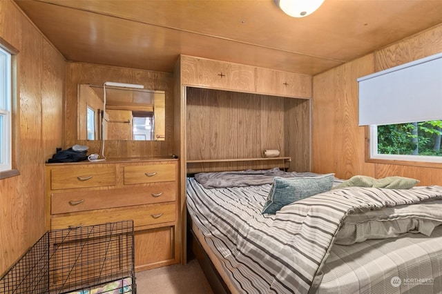 bedroom with carpet, wooden ceiling, and wooden walls