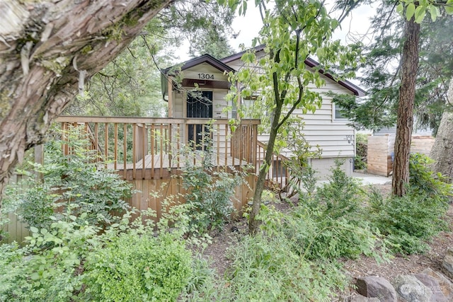 rear view of house with a deck and a garage