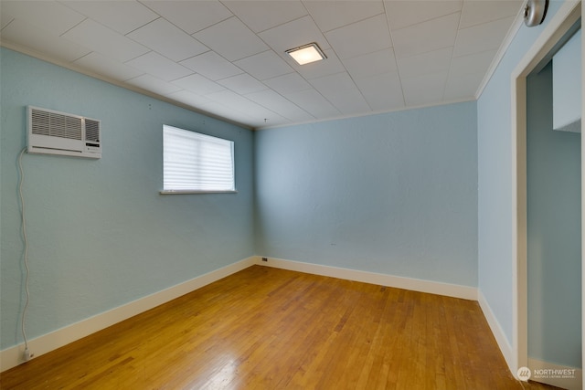 empty room with hardwood / wood-style floors and a wall mounted air conditioner