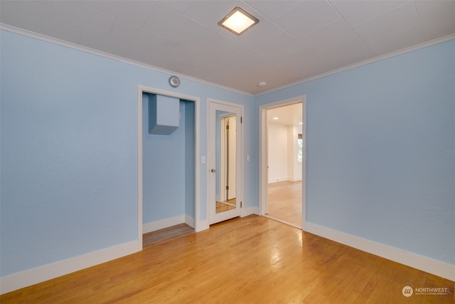 unfurnished room featuring ornamental molding and light hardwood / wood-style floors