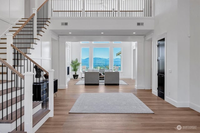 entrance foyer featuring light hardwood / wood-style floors and a towering ceiling