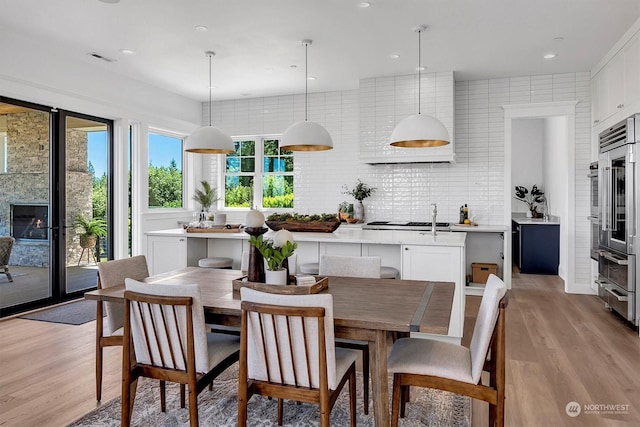 dining space featuring a large fireplace and light hardwood / wood-style floors