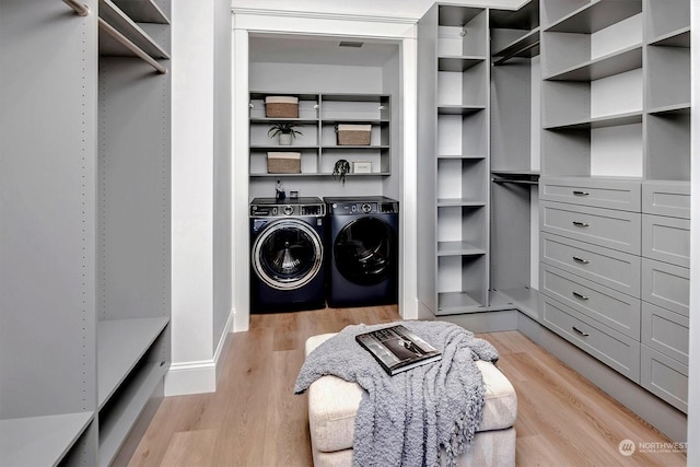 walk in closet featuring washing machine and dryer and light hardwood / wood-style floors