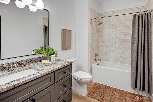 full bathroom featuring hardwood / wood-style flooring, vanity, toilet, and shower / tub combo with curtain