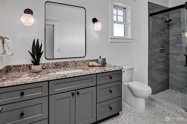 bathroom with tile patterned flooring, vanity, toilet, and a shower with door