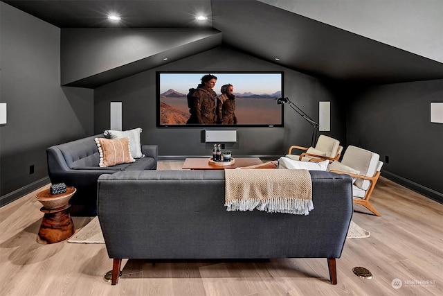 home theater room with light hardwood / wood-style floors and lofted ceiling