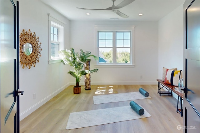 exercise room featuring ceiling fan and light wood-type flooring