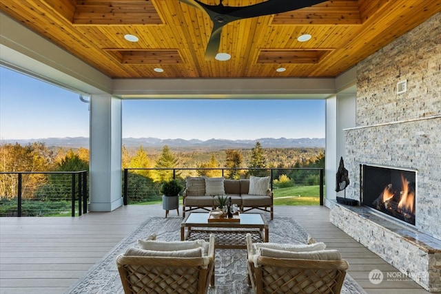 wooden deck with an outdoor living space with a fireplace and a mountain view