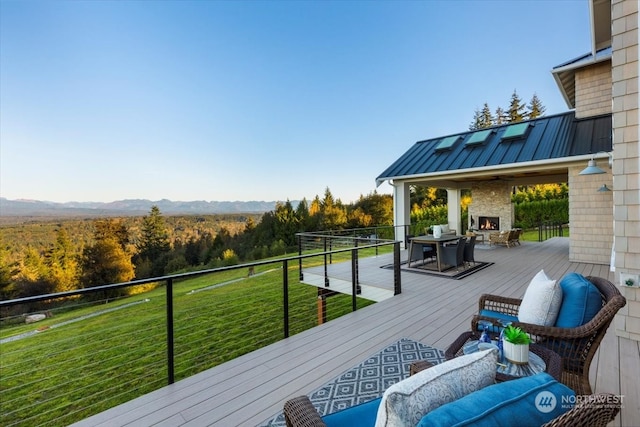 wooden deck featuring a mountain view and exterior fireplace