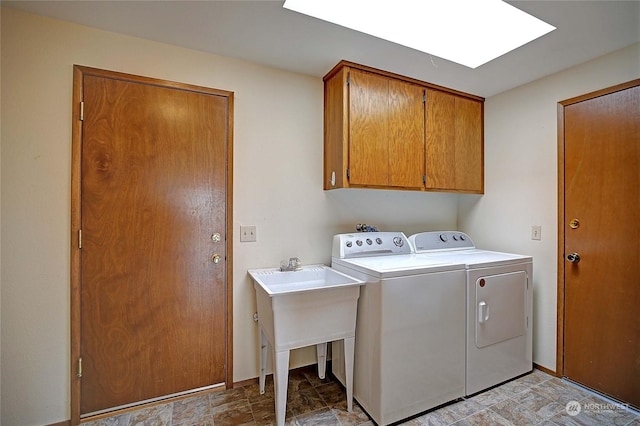 laundry room featuring separate washer and dryer, a skylight, and cabinets