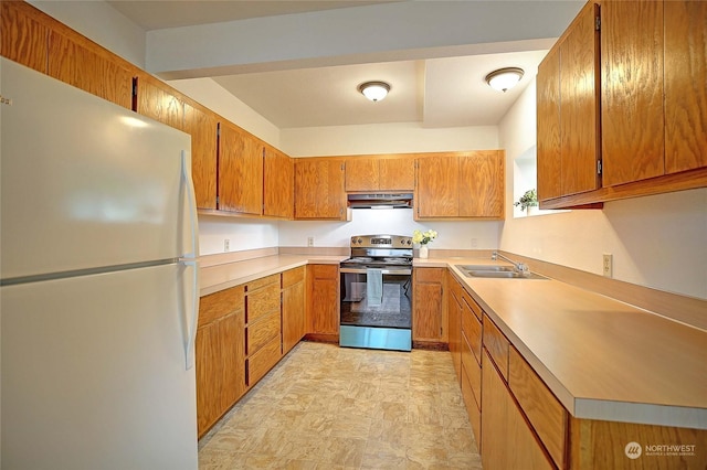 kitchen featuring stainless steel electric range oven, sink, and white refrigerator