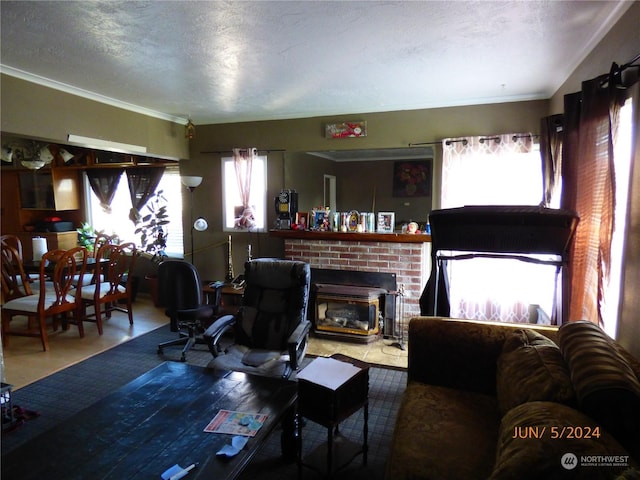 living room with ornamental molding, a textured ceiling, and a fireplace