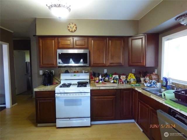 kitchen with tasteful backsplash, white appliances, and sink