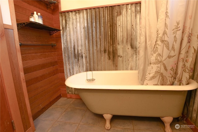 bathroom featuring tile patterned floors, wood walls, and a washtub