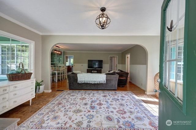 living room featuring a chandelier, hardwood / wood-style floors, and crown molding