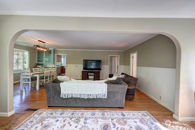 living room featuring crown molding and a notable chandelier