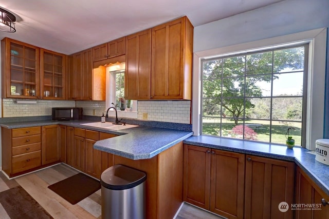 kitchen with decorative backsplash, sink, and light hardwood / wood-style flooring