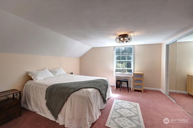 bedroom with carpet flooring, lofted ceiling, and a closet