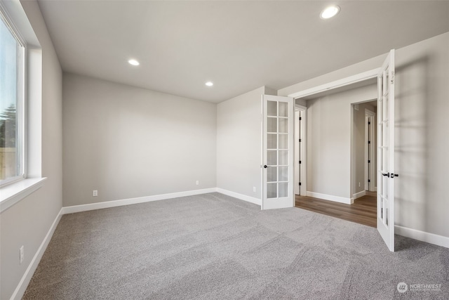 spare room with a wealth of natural light, carpet, and french doors