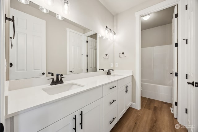 bathroom featuring vanity, hardwood / wood-style flooring, and shower / washtub combination