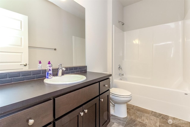 full bathroom featuring bathing tub / shower combination, toilet, vanity, and tasteful backsplash