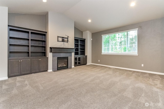 unfurnished living room with light colored carpet and lofted ceiling