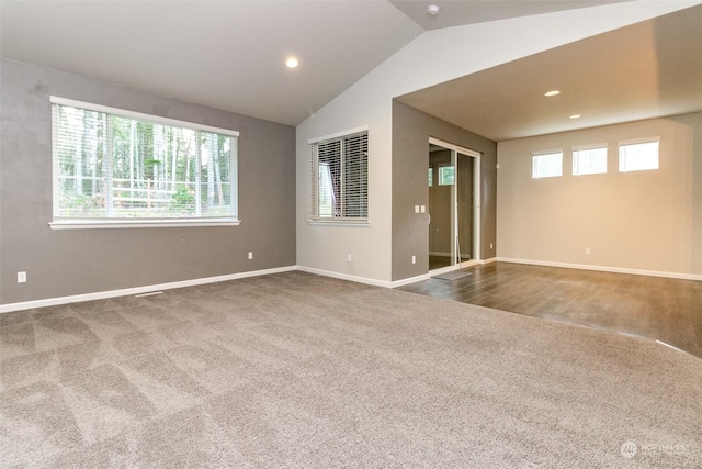 carpeted empty room featuring vaulted ceiling