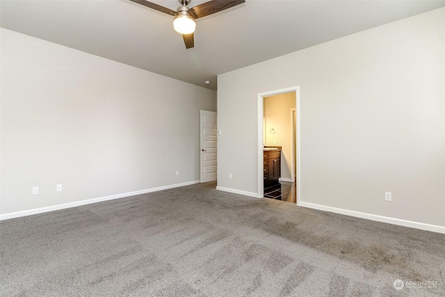 unfurnished bedroom with ceiling fan, dark carpet, and ensuite bath