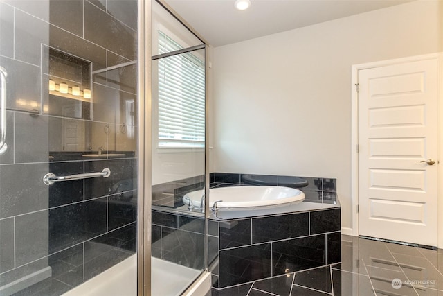 bathroom with independent shower and bath and tile patterned flooring