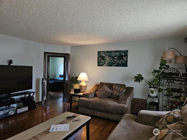 living room with a textured ceiling and dark hardwood / wood-style floors