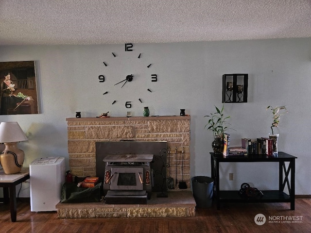 interior details with wood-type flooring, a wood stove, and a textured ceiling