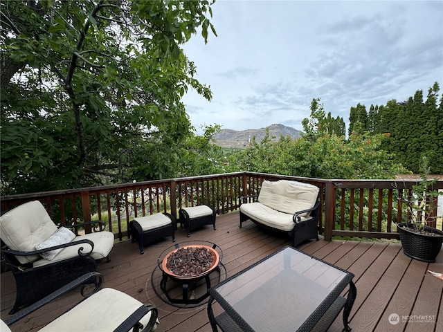 wooden terrace featuring a fire pit and a mountain view