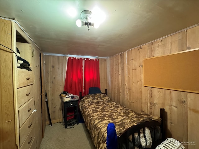 bedroom featuring wood walls and light carpet