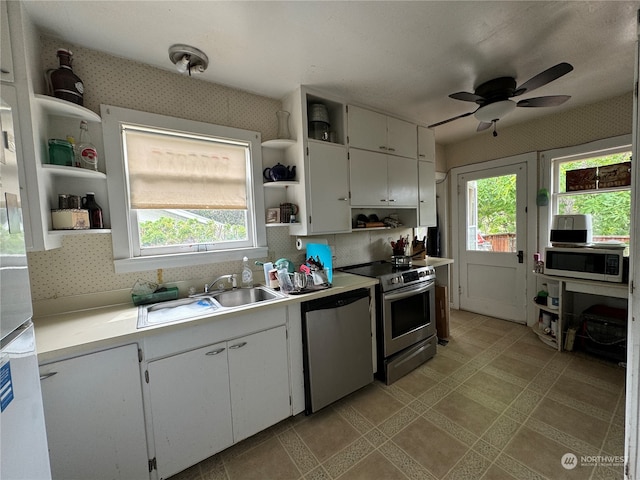 kitchen with plenty of natural light, ceiling fan, white cabinets, and appliances with stainless steel finishes