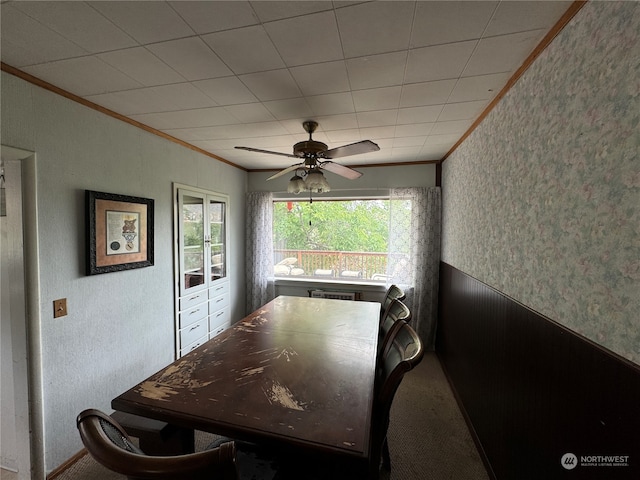 carpeted dining area featuring crown molding and ceiling fan