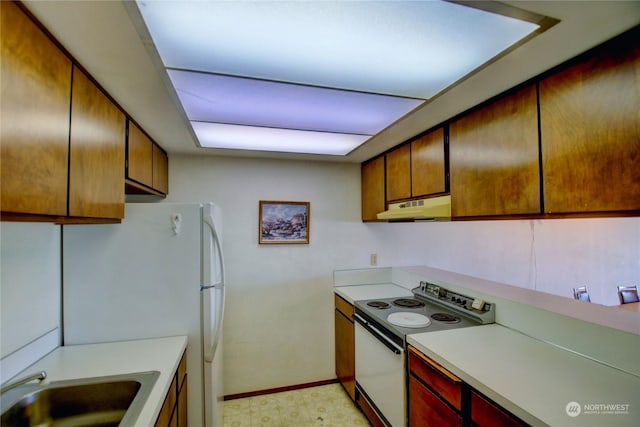 kitchen with electric range, white refrigerator, and sink