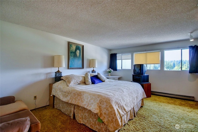 bedroom featuring a textured ceiling, baseboard heating, and multiple windows