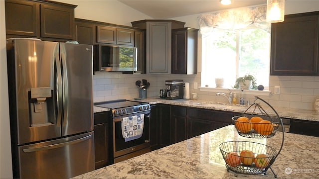 kitchen with dark brown cabinetry, stainless steel appliances, tasteful backsplash, and sink