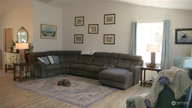 living room with light wood-type flooring and vaulted ceiling