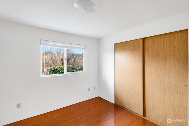 unfurnished bedroom featuring a closet and hardwood / wood-style flooring