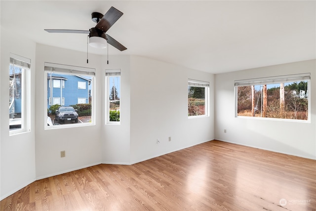 spare room featuring ceiling fan, light hardwood / wood-style floors, and plenty of natural light