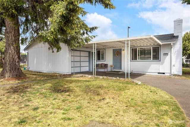 ranch-style house featuring a garage and a front lawn