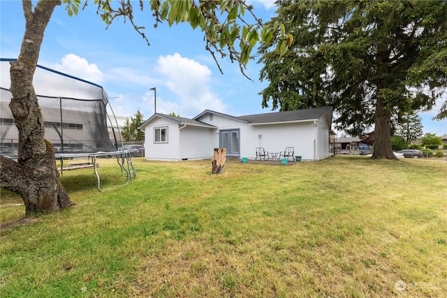 exterior space featuring a trampoline and a lawn