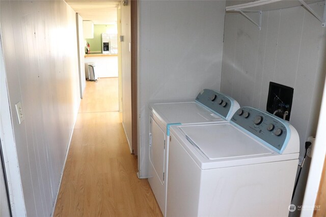 laundry area with separate washer and dryer and light hardwood / wood-style floors