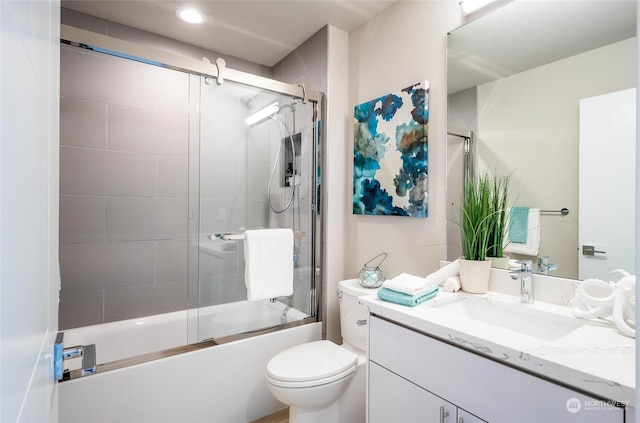 full bathroom featuring vanity, toilet, and bath / shower combo with glass door