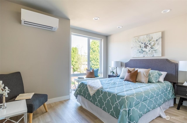 bedroom featuring a wall mounted air conditioner and light wood-type flooring