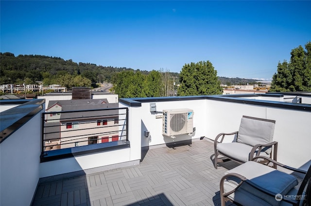 view of patio featuring ac unit and a balcony